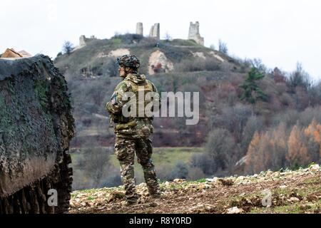 A member of the Slovenian armed forces looks over the horizon during exercise Combined Resolve XI in Hohenfels Training Area, Germany, Dec. 7, 2018.      CBRXI gives the U.S. Army’s regionally allocated forces in Europe the opportunity to execute a combat training center rotation with a joint, multinational environment demonstrating their integration into U.S. Army Europe operations. Stock Photo