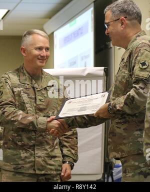 Col. Guy Reedy, 184th Sustainment Command receives a Hero of The Battle certificate from Brig. Gen. Clint E. Walker, 184 SC commander. Reedy was awarded for his professionalism and proficiency during the units validation for the upcoming deployment. Stock Photo