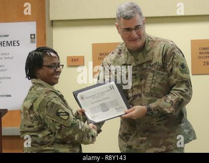 Staff Sgt. Marieka Thompson, 184th Sustainment Command receives a Hero of The Battle certificate from Brig. Gen. Clint E. Walker, 184 SC commander. Thompson was awarded for her professionalism and proficiency during the units validation for the upcoming deployment. Stock Photo