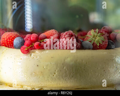 Big white ice cream vanilla cake with fresh red forest berries close up Stock Photo