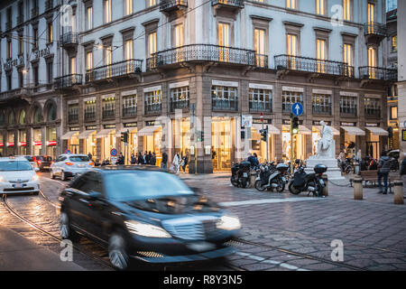 Milan, Italy - November 2, 2017: Pedestrians and car traffic on a typical shopping street in downtown Milan on a fall day Stock Photo