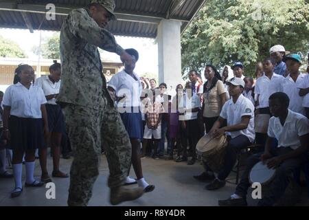 TRUJILLO, Honduras (Feb. 27, 2017) - Equipment Operator 2nd Class Elijah Godbold, a native of Augusta, Ga., Assigned to Construction Battalion Maintenance Unit (CBMU) 202, dances with host nation children during a cultural demonstration during Continuing Promise 2017 (CP-17) in Trujillo, Honduras.  CP-17 is a U.S. Southern Command-sponsored and U.S. Naval Forces Southern Command/U.S. 4th Fleet-conducted deployment to conduct civil-military operations including humanitarian assistance, training engagements, medical, dental, and veterinary support in an effort to show U.S. support and commitment Stock Photo