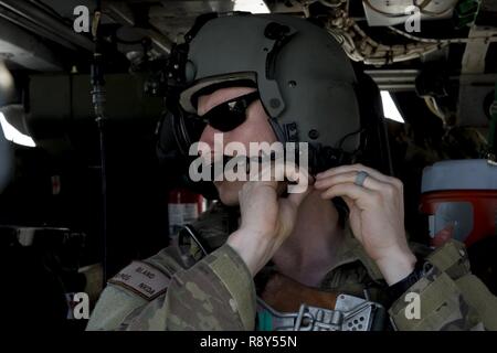 A HH-60 Pavehawk aerial gunner, from the 303rd Expeditionary Rescue Squadron, prepares for a training flight March 2, 2017, around Camp Lemonnier, Djibouti. The 303rd EQRS are part of the 449th Air Expeditionary Group Personnel Recovery Task Force, where they conduct continuous personnel recovery activities to enable regional actors to neutralize violent extremist organizations within East Africa and the Arabian Peninsula in order to protect and defend United States interests. Stock Photo