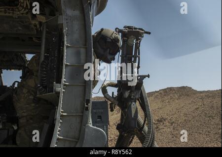 A HH-60 Pavehawk aerial gunner, from the 303rd Expeditionary Rescue Squadron, surveys the surrounding land during a training flight March 2, 2017, around Camp Lemonnier, Djibouti. The 303rd EQRS are part of the 449th Air Expeditionary Group Personnel Recovery Task Force, where they conduct continuous personnel recovery activities to enable regional actors to neutralize violent extremist organizations within East Africa and the Arabian Peninsula in order to protect and defend United States interests. Stock Photo