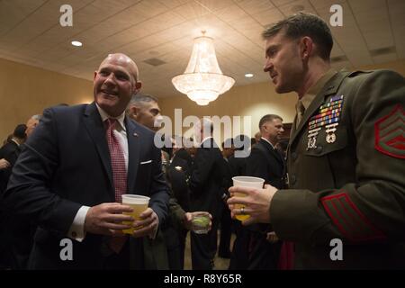 Sgt. Maj. Micheal Barrett (ret.), right, speaks to Marines and Sailors with 1st Marine Logistics Group during the 1st MLG Officer and Staff Noncommissioned Officer Mess Night at Camp Pendleton, Calif., March 3, 2017. Barrett, the 17th Sergeant Major of the Marine Corps, was the honored guest at the mess night, an event designed to foster camaraderie and esprit de corps. Stock Photo