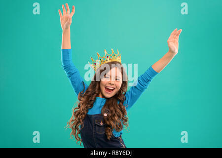 Feels like queen. Kid wear golden crown symbol of princess. Lady little princess. Girl cute baby wear crown while stand blue background. Childhood concept. Every girl dreaming to become princess. Stock Photo