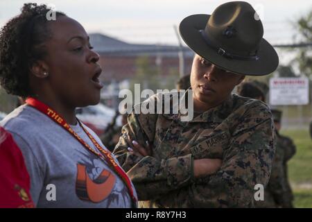 Staff Sergeant Simone King, Senior Drill Instructor, 4th Battalion, Recruit Training Regiment, instructs Kristin Tolman a school resource officer with Recruiting Station Columbia during the Recruiting Station Atlanta/Columbia Educators Workshop aboard Marine Corps Recruit Depot Parris Island, South Carolina, Mar. 8, 2017. The Educators come from both Recruiting Station Atlanta and Columbia to experience the Educators Workshop. The Educators Workshop provides an opportunity to educators to have an inside look at Marine Corps training to better inform the students in their local area. Stock Photo
