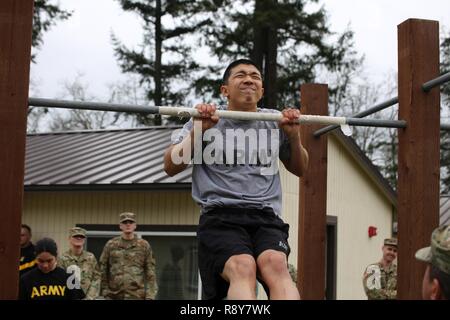 Washington National Guard soldier Cadet Kevin Jiang, Alpha Company 1st Battalion, 161st Infantry Regiment, performs the pull-up during the Best Warrior competition, March 3, 2017, Joint Base Lewis-McChord, Wash. The competitors had to perform as many pull-ups as possible without coming down from the bar. Stock Photo