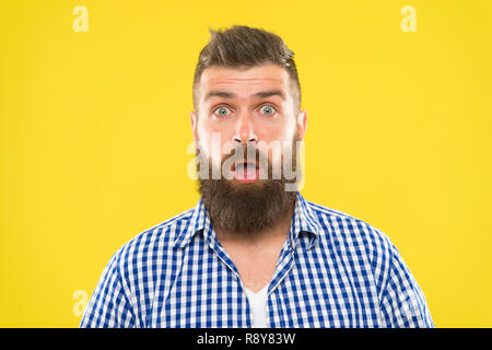 Guy surprised face expression. Hipster with beard and mustache emotional surprised expression. Rustic surprised macho. Surprising news. Man bearded hipster wondering face yellow background close up. Stock Photo