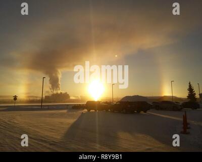 The sun rising over Eielson AFB, Alaska, created a sundog or mock Sun, and greeted residents of the interior-Alaska base on this -30° morning, March 9, 2017. According to astronomers, a sundog is formed when sunlight refracts through icy clouds containing hexagonal platecrystals aligned with their large, flat faces parallel to the ground, and since Eielson has a lot of icy clouds hanging around right now, sundogs are a common occurrence and a part of our military life. Stock Photo