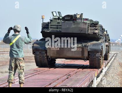 CAMP HUMPHREYS, South Korea – Soldiers from 2nd Battalion, 34th Armor Regiment, 1st Armored Brigade Combat Team, 1st Infantry Division, offload an M1 Abrams tank from a rail car during relocation operations on Camp Humphreys in Pyeongtaek, South Korea Feb. 24.  The relocation, part of a 2014 bilateral agreement between the U.S. and the Republic of Korea, saw the battalion move its armored vehicle systems via railcar while the rest of their wheeled vehicle fleet moved by way of convoy from Casey to Humphreys. Stock Photo