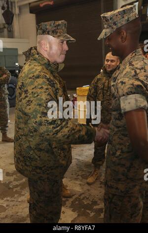 U.S. Marine Corps Lt. Gen. John E. Wissler, Commander, U.S. Marine Corps Forces Command, Commanding General, Fleet Marine Forces, Atlantic, left, shakes hands with Lance Cpl. Nathaniel Warnsley, Heavy Equipment Operator, 2nd Transportation Support Battalion, Combat Logistics Regiment 2, 2nd Marine Logistics Group (MLG), during his trip to Camp Lejeune, N.C., March 15, 2017. Wissler visited 2nd MLG to conduct a commanders workshop, engage senior leaders on designated topics, and observe training activities at various 2D MLG units. Stock Photo