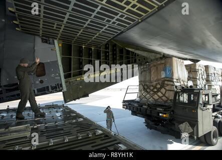 Senior Airman Elias Wilson, 22nd Airlift Squadron, marshals in a K-loader with pallets of unaccompanied baggage at Osan Air Base, South Korea, March 7, 2017. The pallets of unaccompanied baggage were returned back to the United States for service members who are being reassigned. Stock Photo