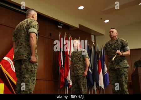 Brig. Gen. Paul K. Lebidine (left), commanding general of 4th Marine Division, Sgt. Maj. Michael A. Miller (middle), incoming sergeant major of 4th MARDIV and Sgt. Maj. Daniel W. Fliegel (right), outgoing sergeant major of 4th MARDIV, participate in a relief and appointment and retirement ceremony at Marine Corps Support Facility New Orleans, March 16, 2017. Composed of more than 17,000 Marines, 4th MARDIV is the biggest division command in the Marine Corps. Stock Photo