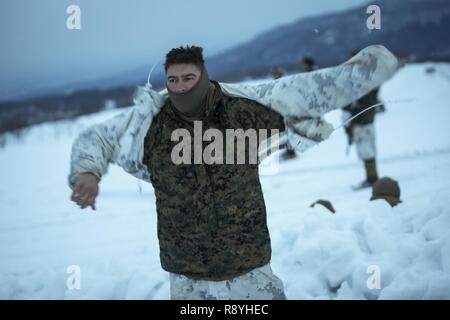 U.S. Marine Lance Cpl. Bryce Graskemper, a Kansas City, Missouri native, warms up by adding warming layers after a patrol during exercise Forest Light at Sekiyama, Japan, March 15, 2017. Forest Light is one of various bi-lateral training opportunities conducted by Japan Ground Self-Defense and deployed U.S. Marine forces to demonstrate the enduring commitment by both countries to peace, stability, and prosperity across the region. Graskemper is an assault man with Company G, 2nd Battalion, 3rd Marine Regiment, 3rd Marine Division, III Marine Expeditionary Force. Stock Photo