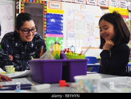 YOKOSUKA, Japan (March 16, 2017) - Boatswain's Mate 3rd Class Erin Marquez, from Pueblo West, Colorado, attached to the U.S. 7th Fleet flagship USS Blue Ridge (LCC 19), helps a student with a math exercise at Sullivan's Elementary School during a community relations event. Blue Ridge is in an extensive maintenance period in order to modernize the ship to continue to serve as a robust communications platform in the U.S. 7th Fleet area of operations. Stock Photo