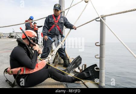 KOREA STRAIT (March 18, 2017) Sonar Technician (Surface) 2nd Class Paden Meinhold, a search and rescue swimmer, from Loveland, Colorado, left, prepares to enter the water while Boatswain's Mate 2nd Class Marte Pena, from Bronx, New York, checks for safety on the forecastle of Ticonderoga-class guided-missile cruiser USS Lake Champlain (CG 57) during a man overboard training evolution. Lake Champlain is on a regularly scheduled Western Pacific deployment with the Carl Vinson Carrier Strike Group as part of the U.S. Pacific Fleet-led initiative to extend the command and control functions of the  Stock Photo
