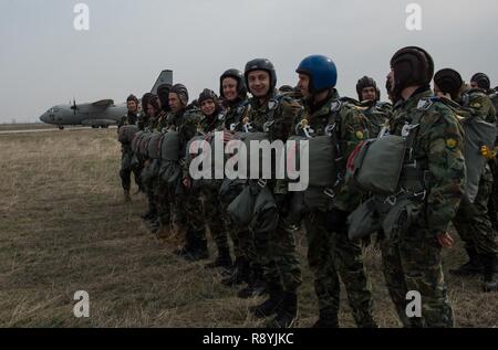 Bulgarian paratroopers wait to load two Super Hercules C-130Js and an Alenia C-27J Spartan during Exercise Thracian Spring 17 over Plovdiv Regional Airport, Bulgaria, March 15, 2017. The 37th AS air crew and 435th Contingency Response Group jump masters from Ramstein Air Base, Germany, worked directly with the paratroopers to conduct tactical flight training. The two-week combined training with Bulgaria’s military aims to facilitate overall relations and build their nations’ joint military capabilities. Stock Photo