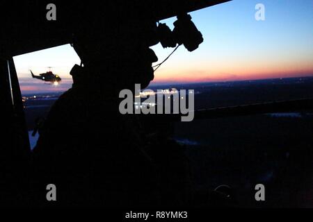 Cpl. Landon Cheek gazes out the back of a UH-1Y Venom during night-time cold weather operations aboard Fort Drum, N.Y., March 17, 2017. Marines assigned to Marine Light Attack Helicopter Squadron 269, Marine Aircraft Group 29, 2nd Marine Aircraft Wing, conducted close air support at night with live ordnance to simulate real world operations in a forward position. Cheek is a crew chief with HMLA-269. Stock Photo