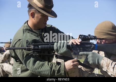 Sgt. Jeffrey A. Sennholtz, a marksmanship trainer with Weapons and Field Training Battalion, teaches Rct. Joanathan T. Broome, Platoon 1026, Bravo Company, 1st Recruit Training Battalion, the correct firing position March 16, 2017, on Parris Island, S.C. Sennholtz, 24, is from DeLand, Fla. Broome, 20, from New Bern, N.C., is scheduled to graduate April 28, 2017. Parris Island has been the site of Marine Corps recruit training since Nov. 1, 1915. Today, approximately 19,000 recruits come to Parris Island annually for the chance to become United States Marines by enduring 12 weeks of rigorous, t Stock Photo