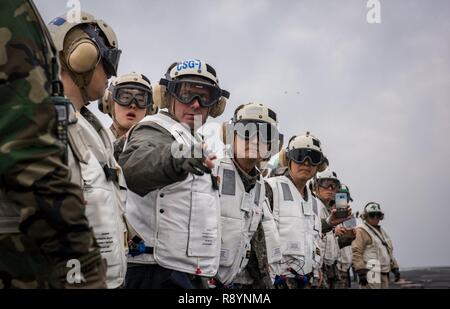 WATERS EAST OF THE KOREAN PENINSULA (March 20, 2017) Rear Adm. Jim Kilby, commander, Carrier Strike Group 1, left, Adm. Um, Hyun Seong, Republic of Korea chief of naval operations, center, and Gen. Jang, Jun Gyu, chief of staff of the Republic of Korea Army, right, observe flight operations on the aircraft carrier USS Carl Vinson (CVN 70) flight deck. The Carl Vinson Carrier Strike Group is on a regularly scheduled Western Pacific deployment as part of the U.S. Pacific Fleet-led initiative to extend the command and control functions of U.S. 3rd Fleet. U.S Navy aircraft carrier strike groups ha Stock Photo