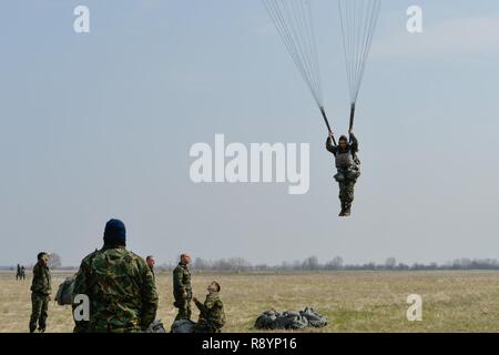 A Bulgarian paratrooper descends from a C-130J Super Hercules during Exercise Thracian Spring 17 at Plovdiv Regional Airport, Bulgaria, March 15, 2017. Airmen from the 37th Airlift Squadron, 435th Contingency Response Group, and 86th Airlift Wing, Ramstein Air Base, Germany, partnered with the Bulgarian military for the two-week exercise. The U.S. Air Force’s forward presence in Europe allows Airmen to work hand-in-hand with Allies to develop and improve ready air forces that are capable of maintaining regional security. Stock Photo