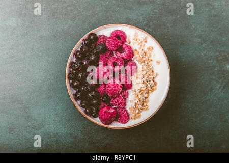 Raspberries and blueberries in a Bowl. Healthy breakfast concept with yoghurt and muesli Stock Photo