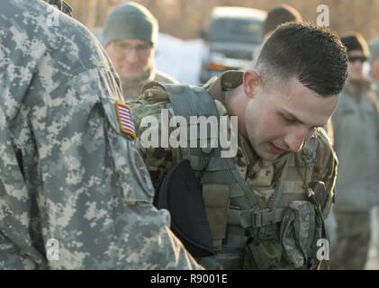 U.S. Army Pfc. Philip Plevel, gunner, Bravo Battery, 1st Battalion, 101st Field Artillery Regiment, Vermont National Guard, rests after completing the 10-kilometer ruck march for the Vermont Best Warrior Competition at Camp Ethan Allen Training Site, Jericho, Vt., March 19, 2017.  Vermont soldiers compete in a variety of Soldier tasks in order to move onto the regional competition in April. Stock Photo