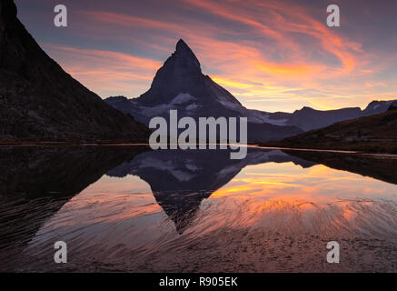 Colourful sunset at the Matterhorn reflected in the Riffelsee. Stock Photo