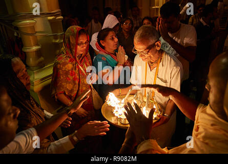 People getting blessings from the holy fire during the morning darshan inside the Sri Krishna Balaram Mandir temple, ISKCON temple of Vrindavan. Uttar Stock Photo