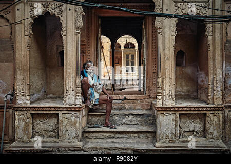 Vrindavan, India - JULY 17: Yogi man sits near the temple of Krishna. Repeats the secret mantra using a rosary. Chanting 108 sacred name of God. July  Stock Photo