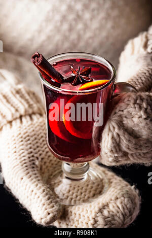 Girl in mittens hold glass of mulled wine Stock Photo
