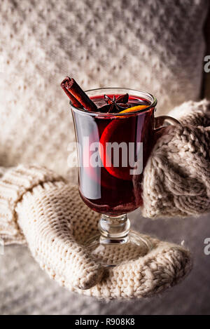 Girl in mittens hold glass of mulled wine Stock Photo