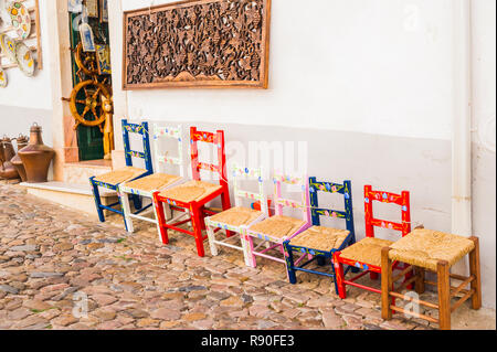 typical multicolored handmade chairs in front of a store selling local handicraft Stock Photo