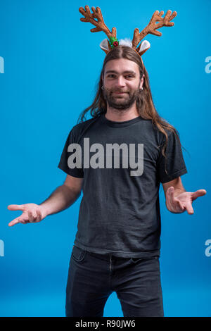 Male wearing raindeer hair band gesturing like wondering with hands. Happy face shot in studio Stock Photo