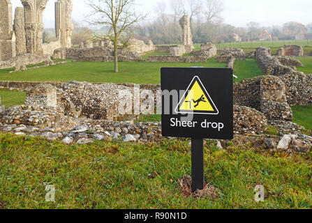 A Sheer Drop sign within the excavated ruins of the Priory Church of St Mary and the Holy Cross at Binham, Norfolk, England, United Kingdom, Europe. Stock Photo