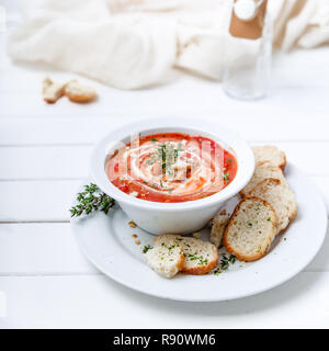 Tomato soup on white with cream and herbs. Top view, copy space Stock Photo