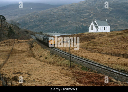 Diesel locomotive passing in front of Lady of The Braes, Roman Catholic chuch, on the West Highland Line,  British Rail Glasgow to Mallaig, Highlands, Scotland Stock Photo