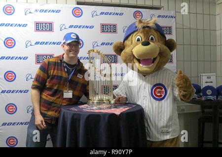 A U.S. Army Soldier's son poses with Clark, the Chicago Cubs mascot, at the  USO at USAG Bavaria in Grafenwoehr, Germany, Dec. 11, 2018. The USO  sponsored a Chicago Cubs mascot tour