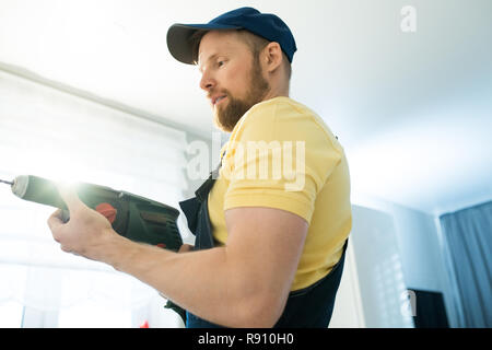 Busy handyman using power drill Stock Photo