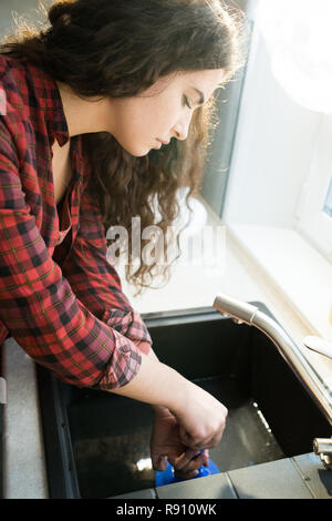Woman clearing clogged drains with plunger Stock Photo