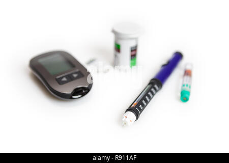 Diabetic mini set of glucometer, strips, box of spare strips and pen injector with spare insulin isolated on white background Stock Photo