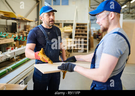 Displeased foreman explaining how to make furniture Stock Photo