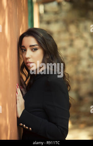 Beautiful young woman leaning against the wall Stock Photo