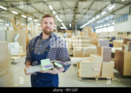 Smiling factory inspector holding folder Stock Photo