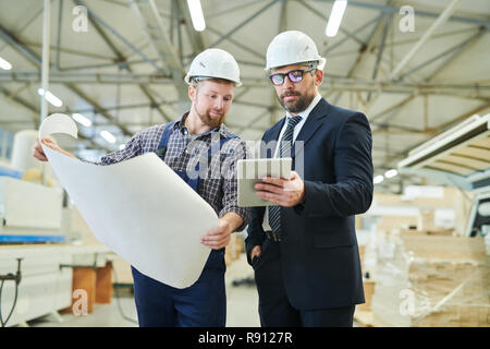 Handsome investor showing online data to engineer Stock Photo