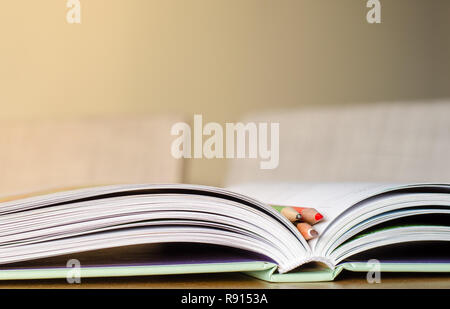 Three pencils in the open book. Reading and study theme background. Stock Photo