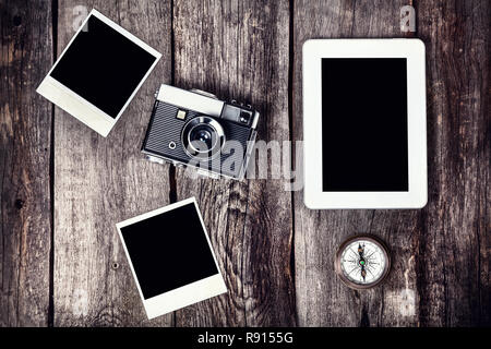 Old film camera, tablet and photos with space for pictures on the wooden background Stock Photo