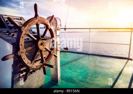 Wooden wheel on the ship at sunset on Issyk Kul lake Stock Photo