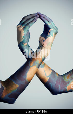 closeup of the arms of two men patterned with a world map (furnished by NASA) forming an awareness ribbon Stock Photo